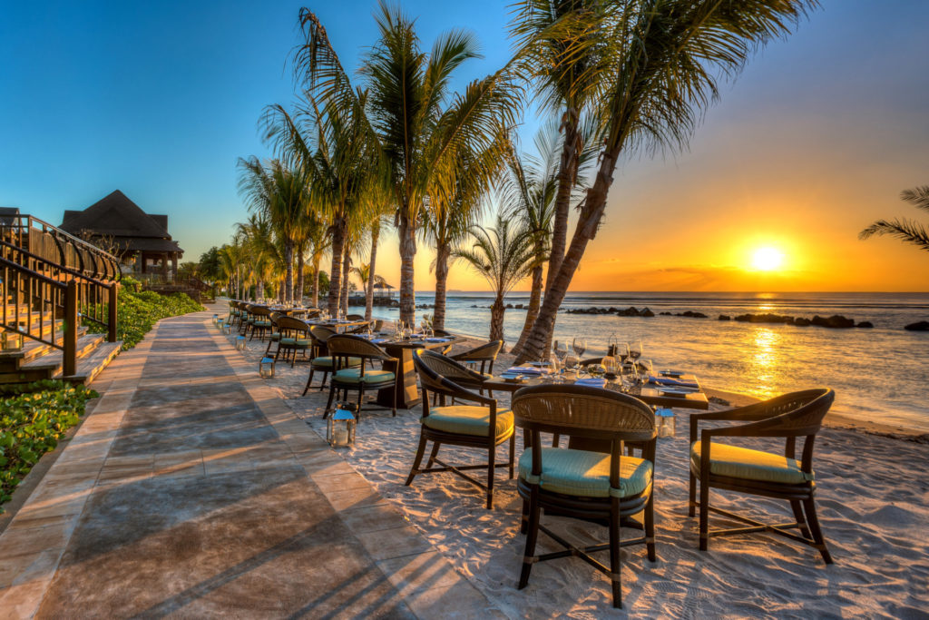 Tables set up on the beach at sunset