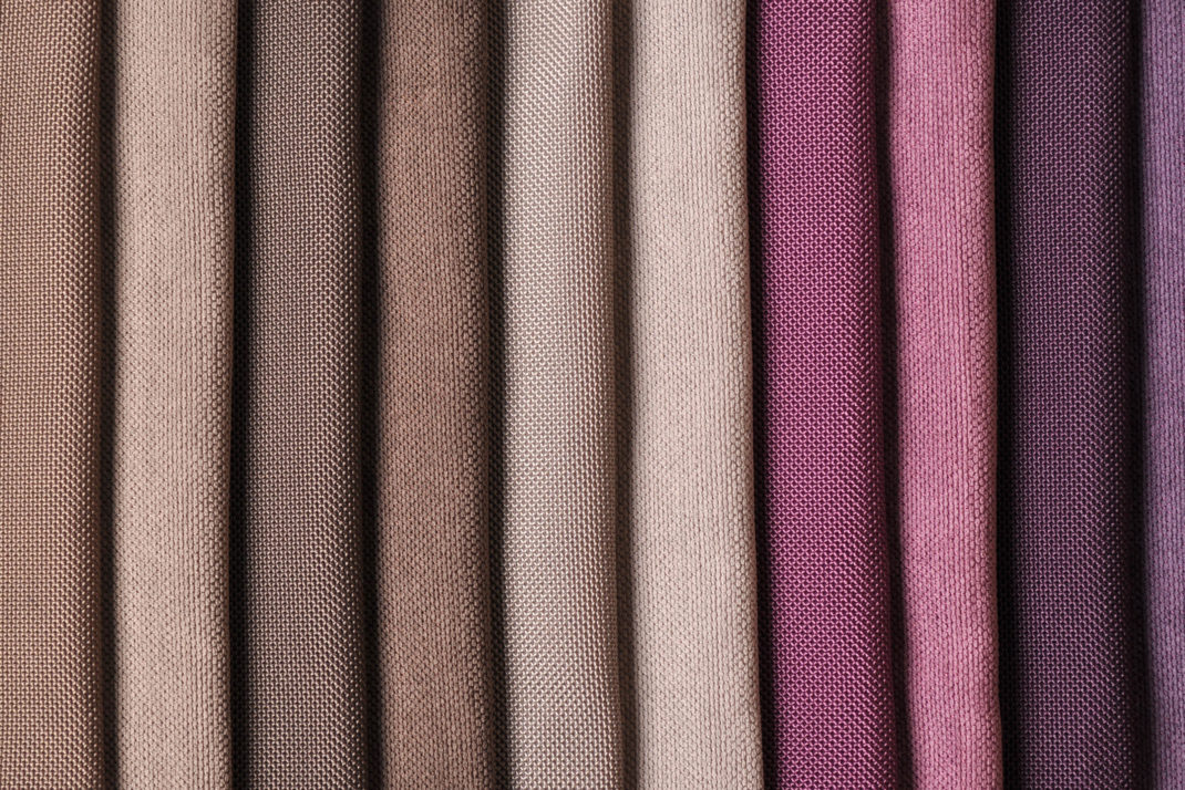 Rainbow clothes background. Pile of bright folded clothes