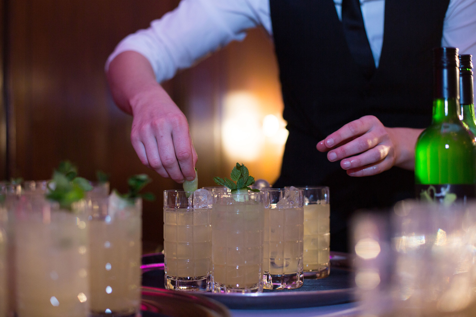 a waiter garnishing cocktails