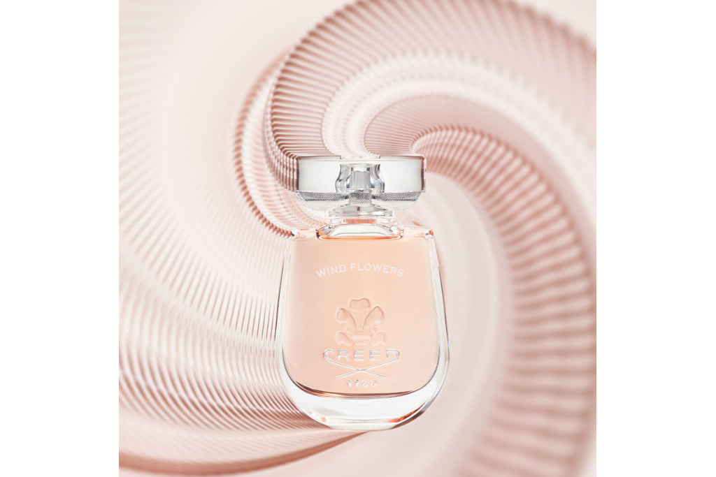 Bottle of Creed Wind Flowers on pink background
