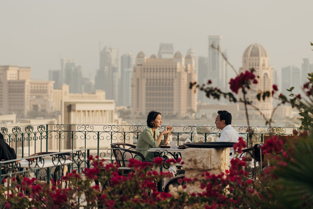 woman and man dining at table overlooking cityscape in qatar