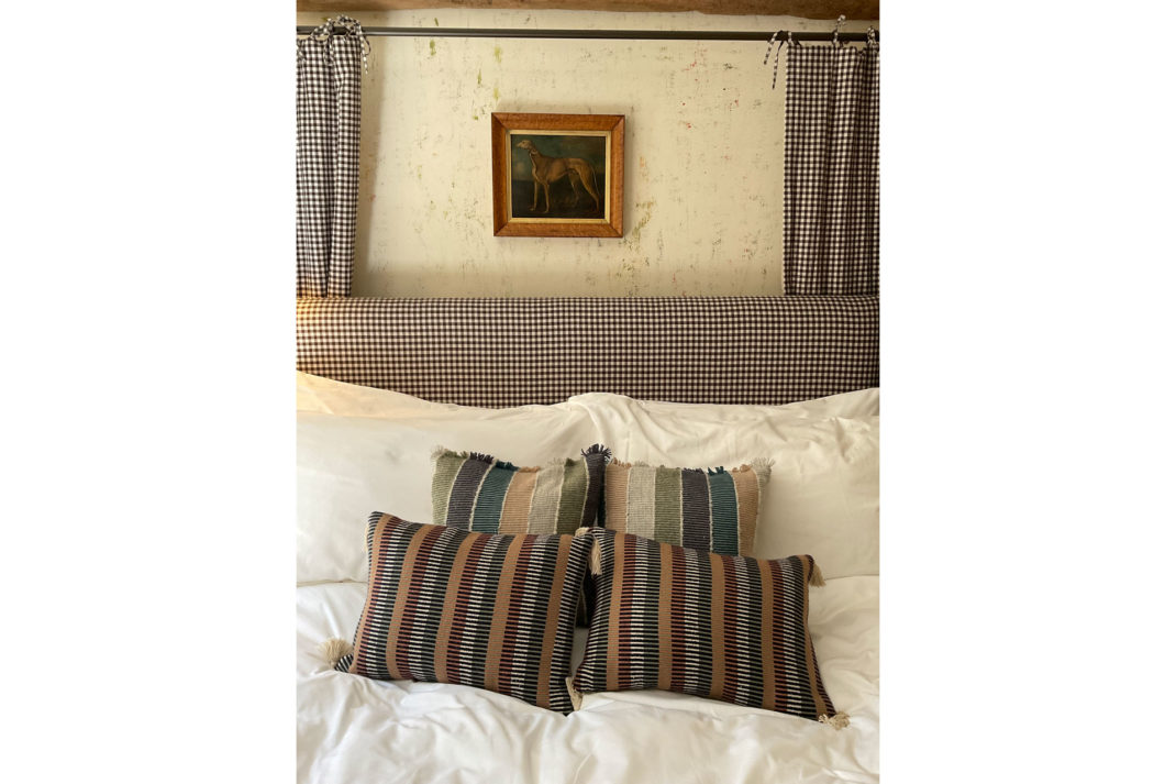 a bedroom, featuring plumped up cushions and an antique portrait of a whippet at The Den suite at The Fox at Oddington
