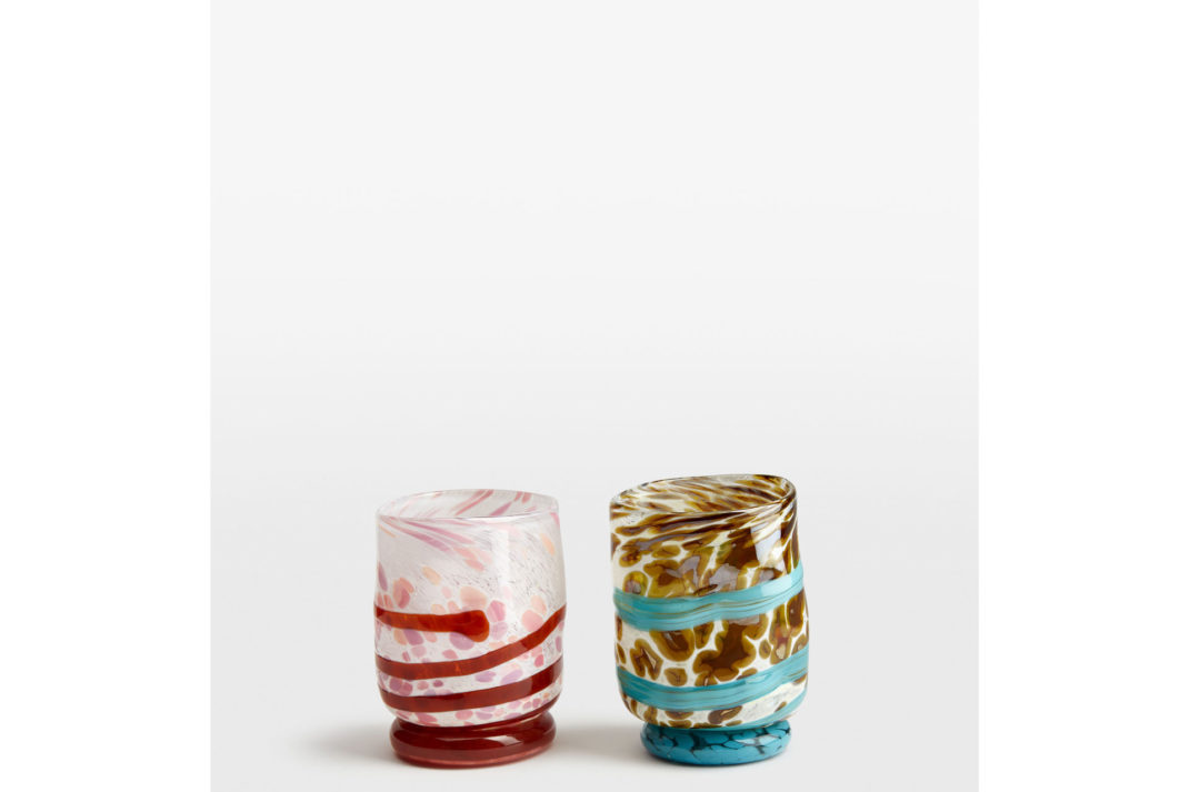 a pair of colourful glass tumblers, one in red and pink, the other in blue and brown colours