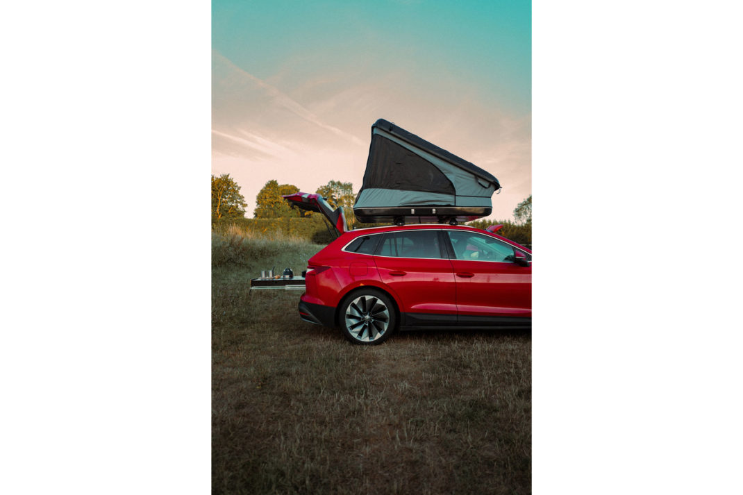 a red car with a roof top camping sleeper