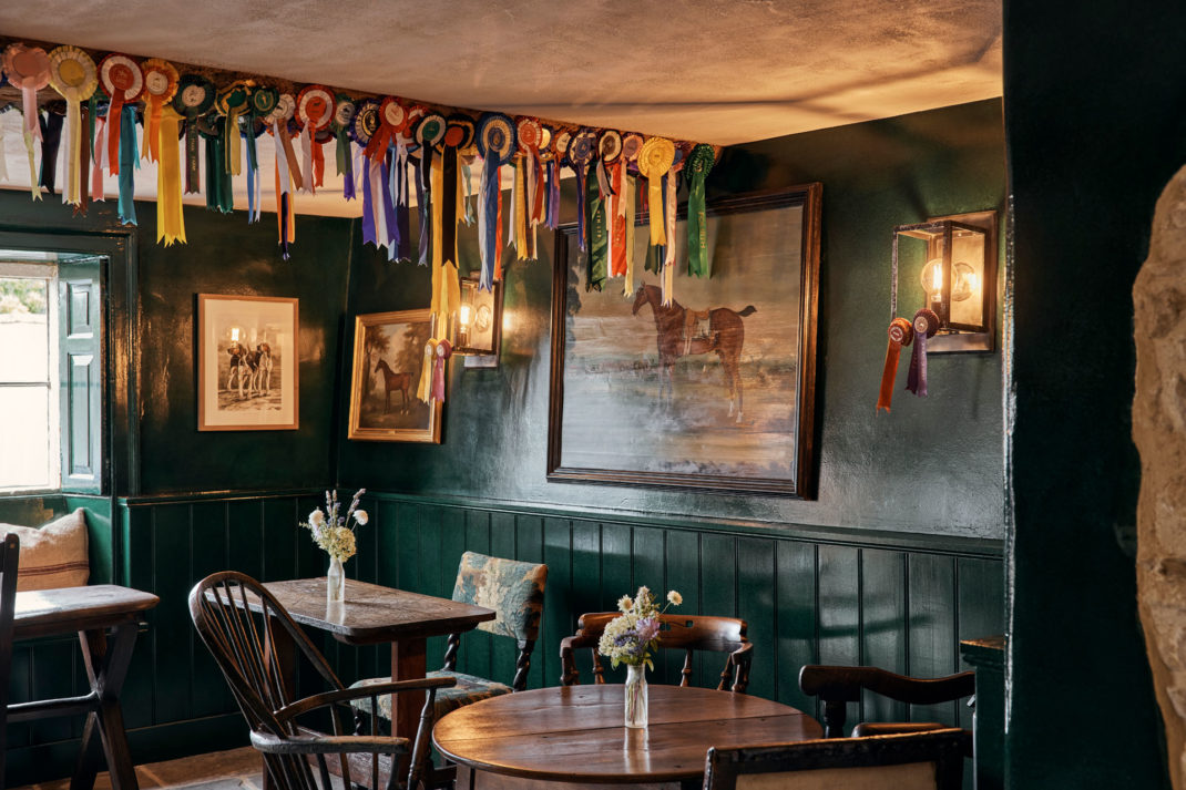 colourful rosettes line the wall of The Tack Room at The Fox at Oddington