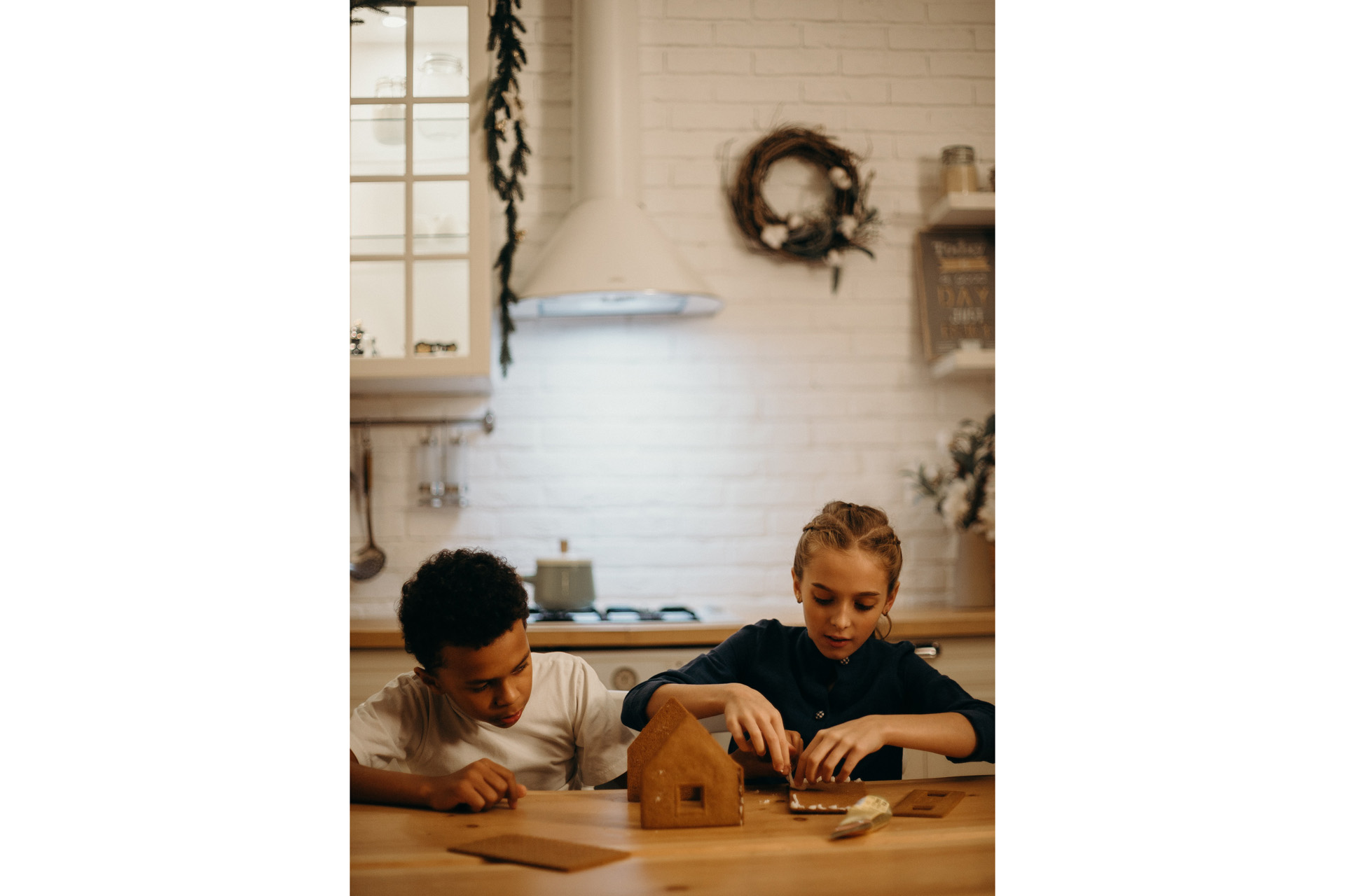 two kids decorating gingerbread houses