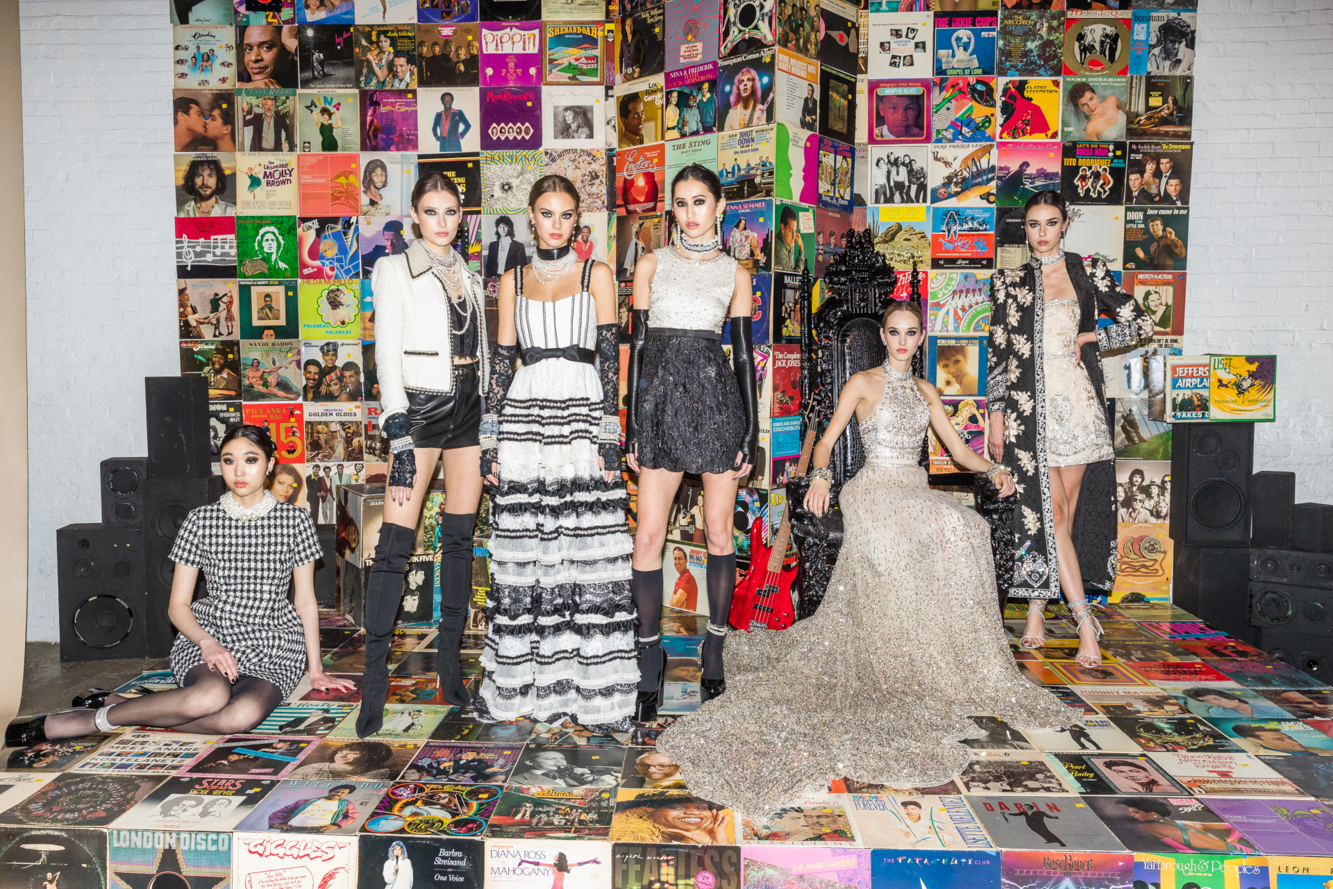 Models in gothcore clothing stood in front of multicoloured backdrop