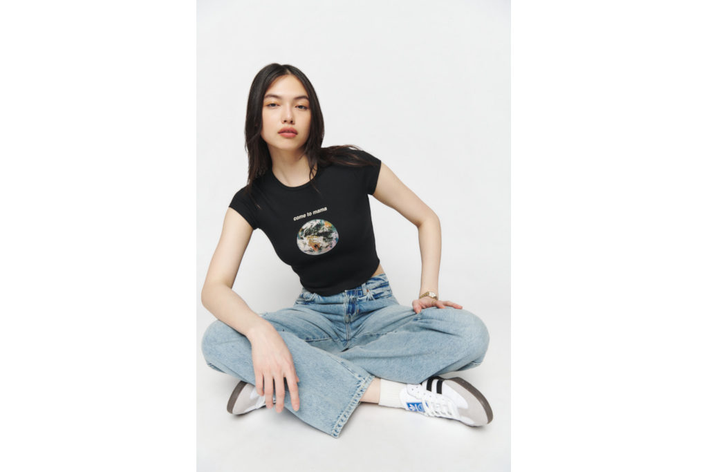 Woman sat cross-legged in black tee and jeans