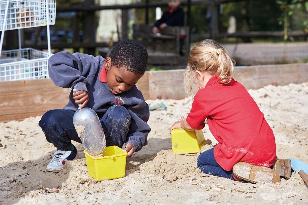 In the sand pit developing motor skills at Brookham School
