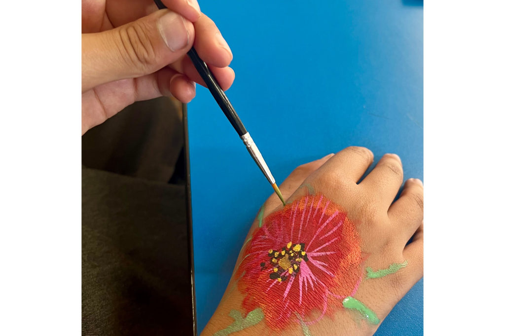 Children painting their representation of the humble poppy on their hands