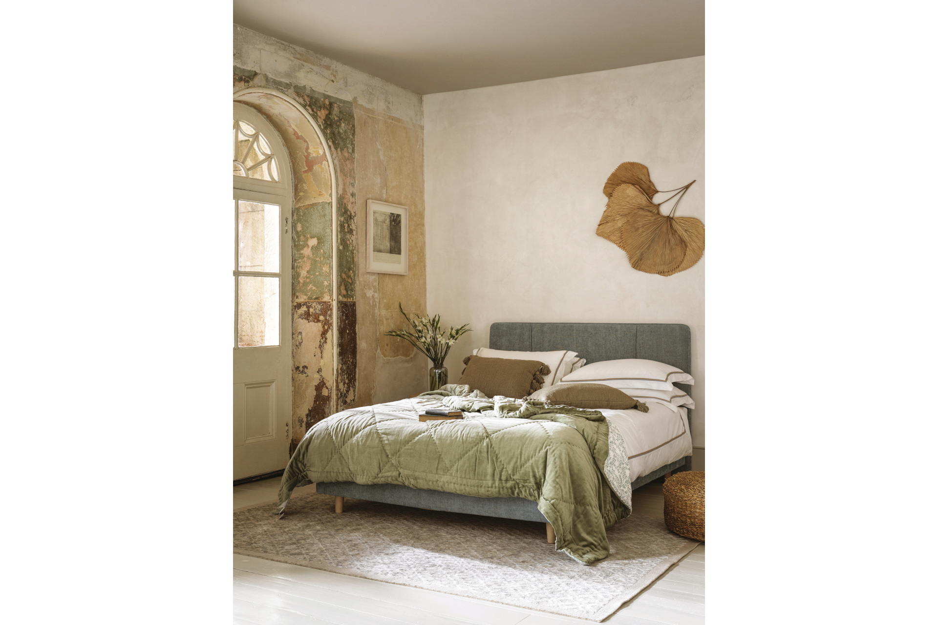 Green bed in rough-walled room