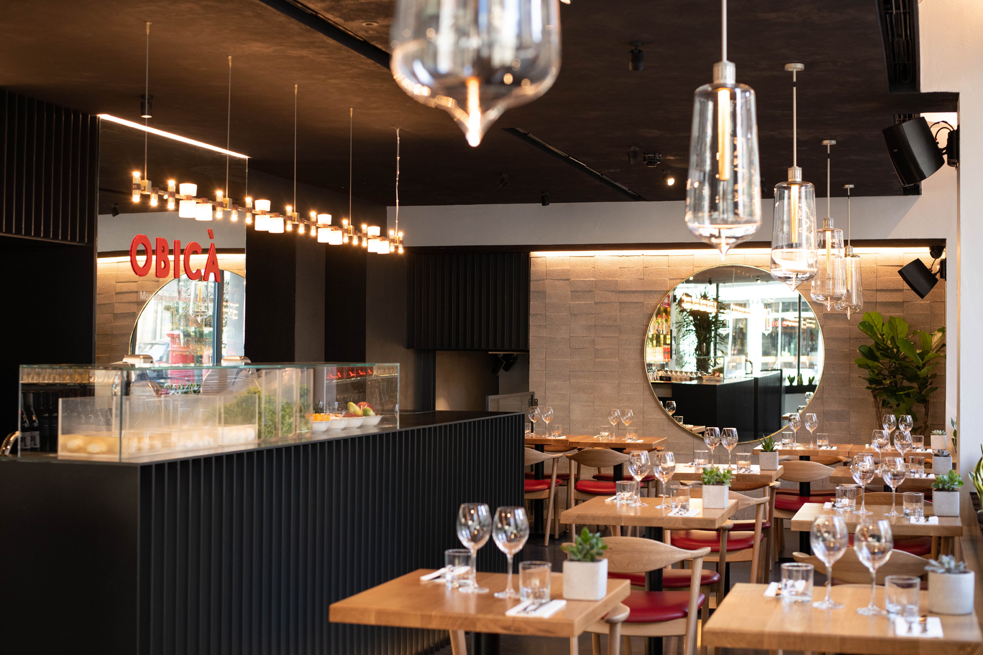 Obica Poland Street interiors, with a black panelled bar and glass hanging lamps.