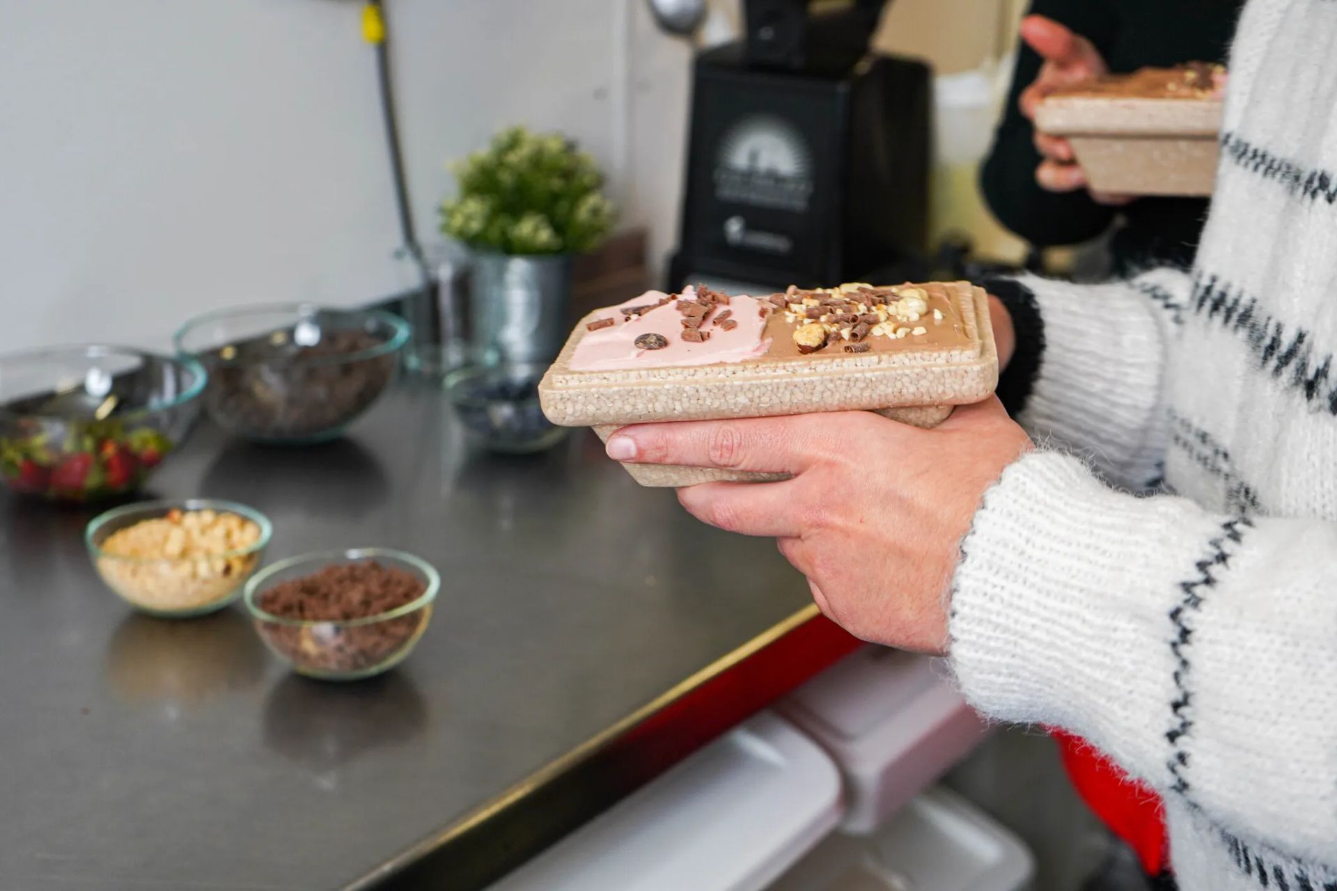 Hands holding a tub of ice cream