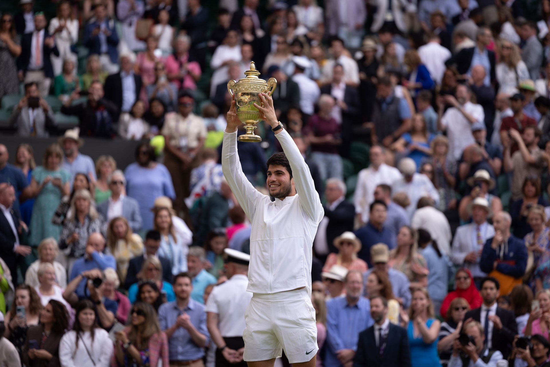 Carlos Alcaraz holding up a trophy at Wimbledon