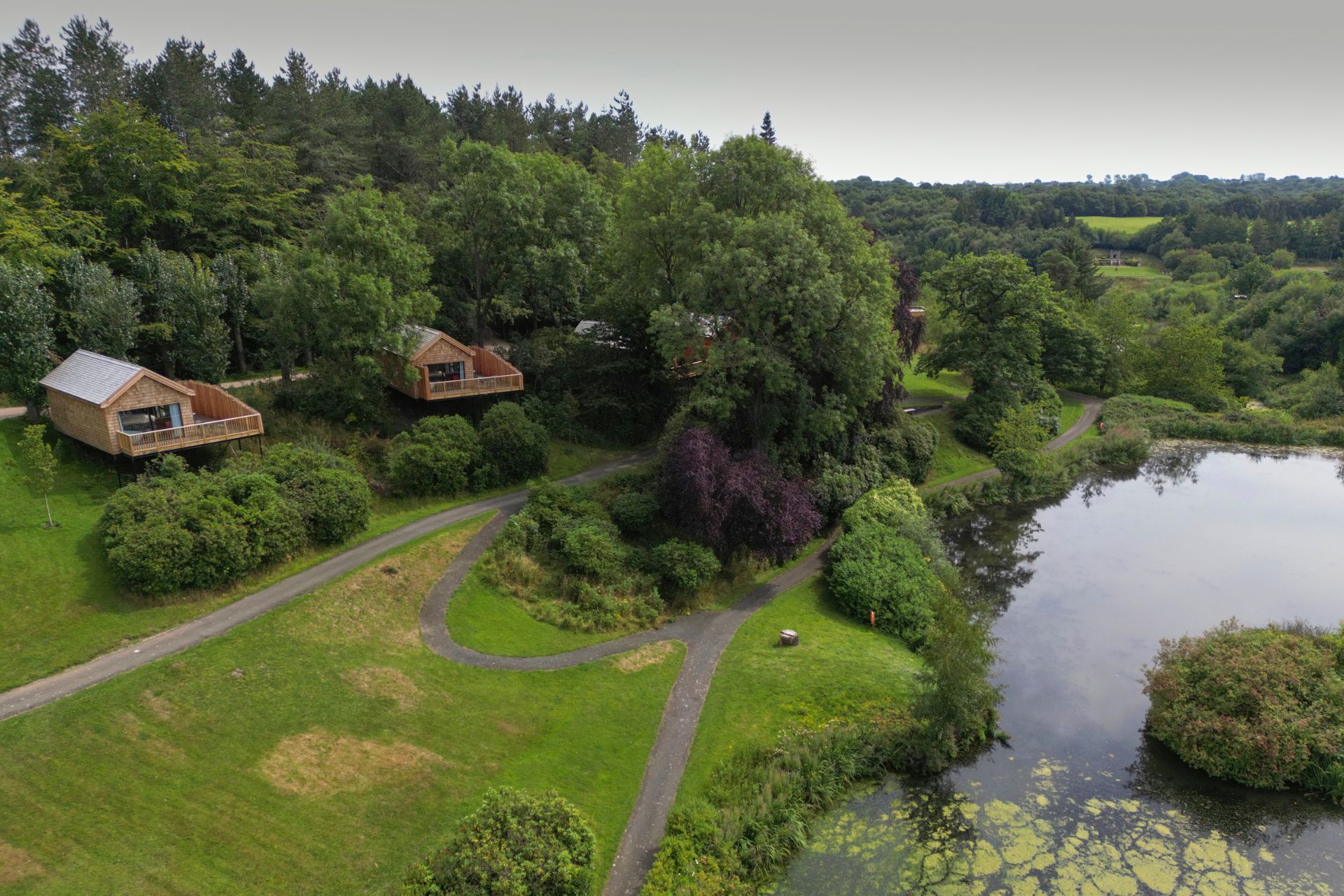 Aerial view of estate with wooden cabins and a lake