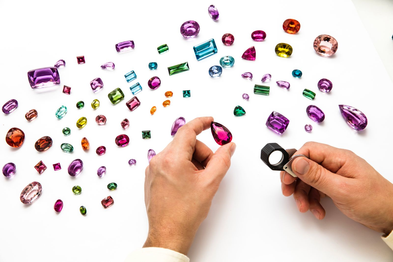Hands hovering over gemstones