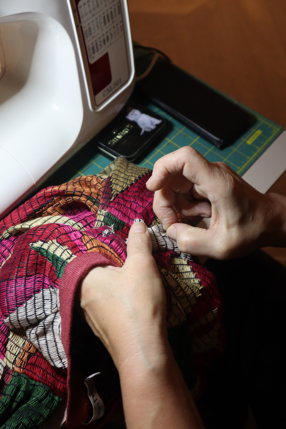 Hands sewing clothing at machines