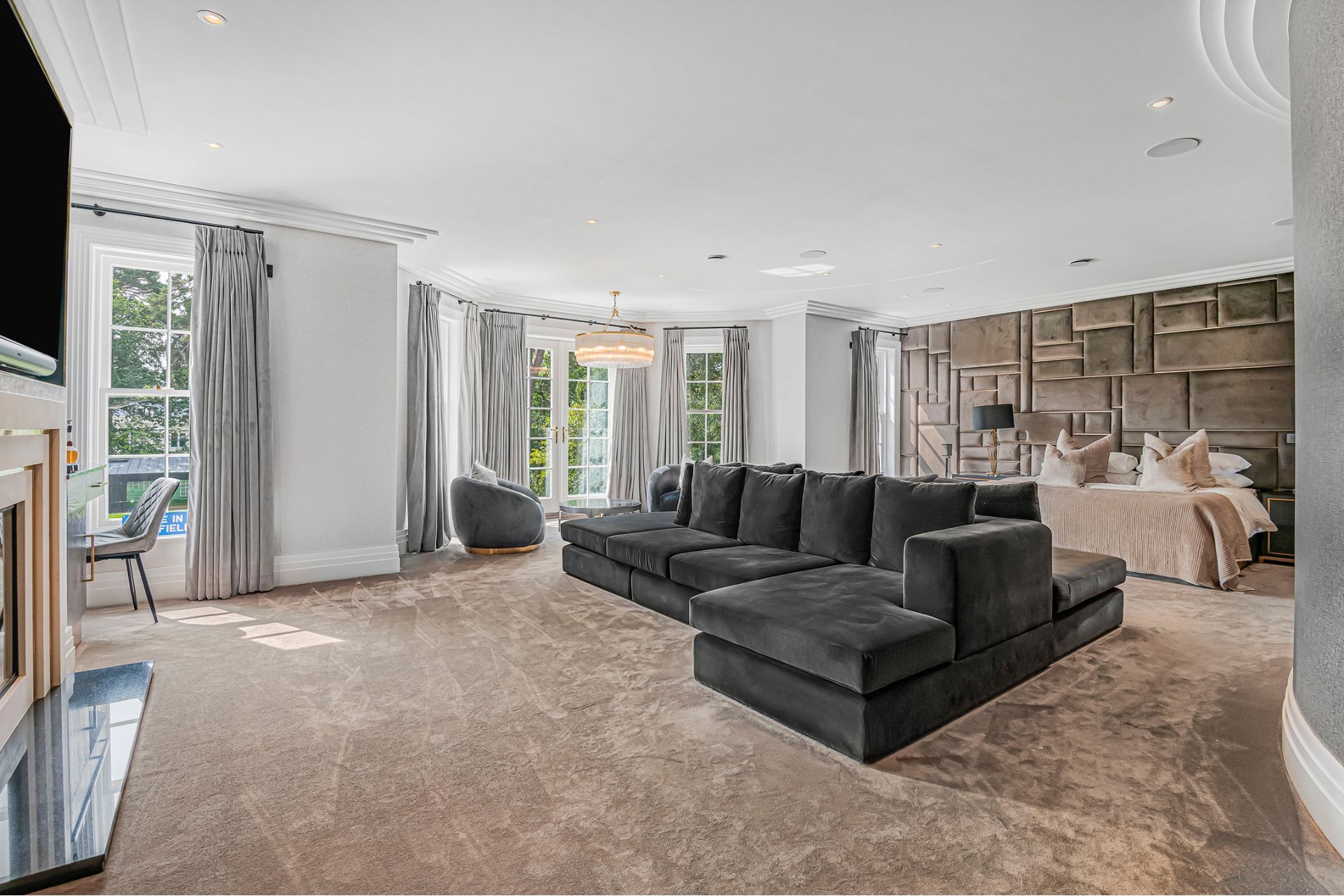 Bedroom with grey sofa and floor-to-ceiling windows