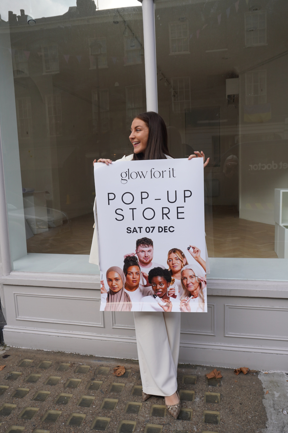 Woman holding up Glow For It poster