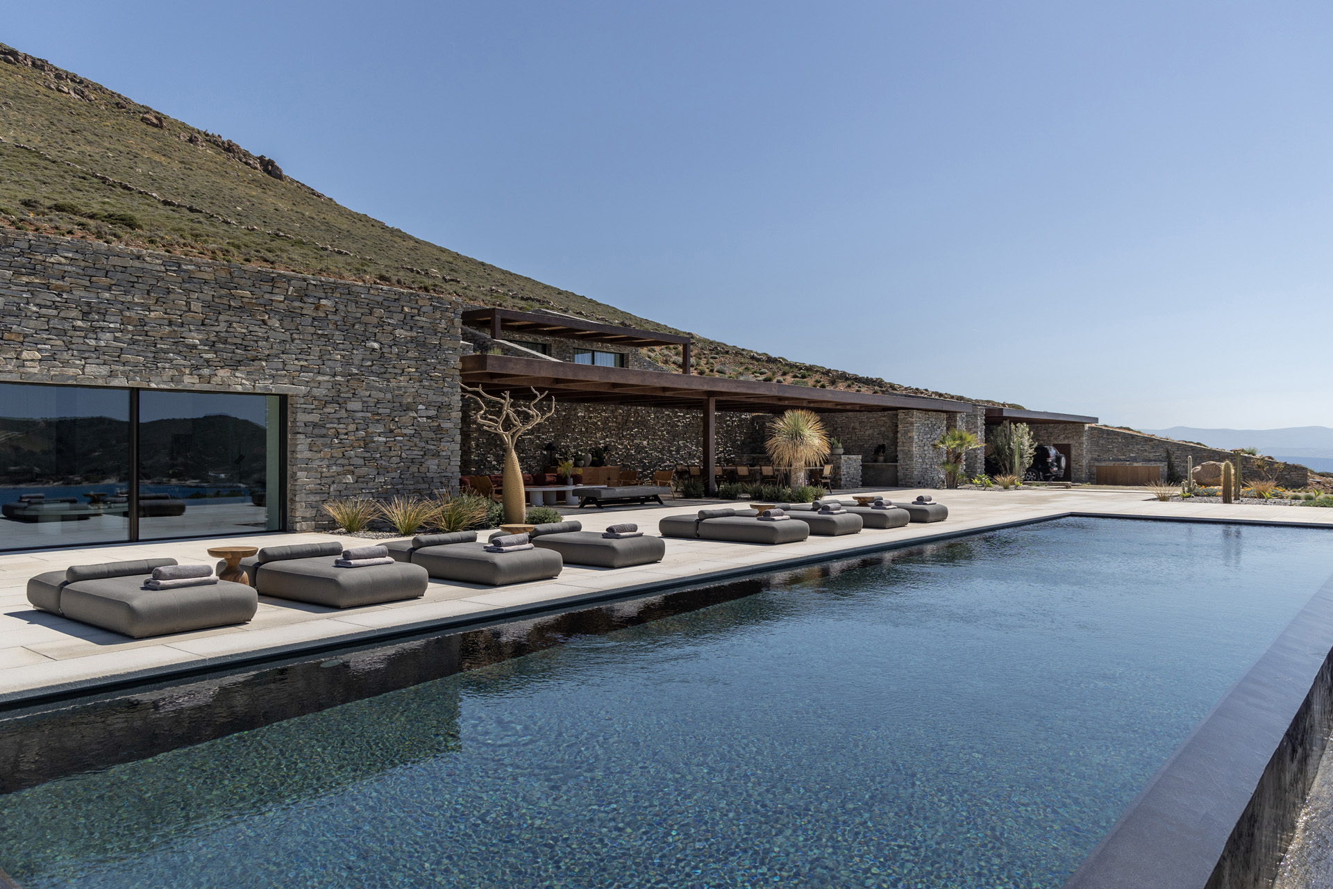 Sun loungers lined up by a swimming pool