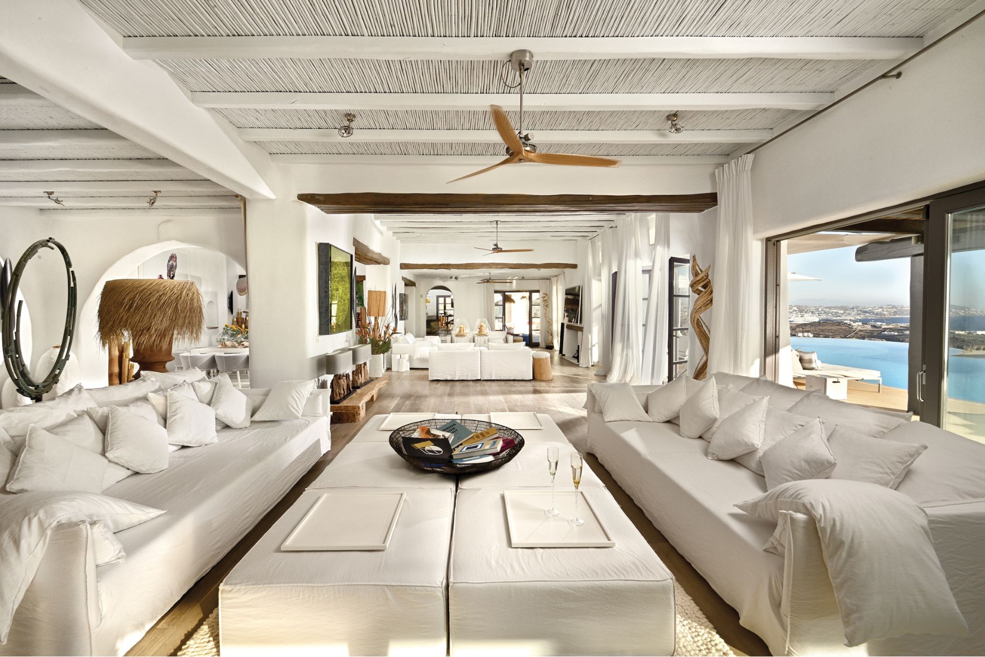 Greek villa living room with white sofas and wooden ceiling beams