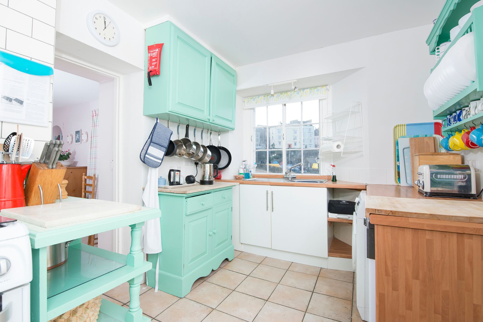 Kitchen with mint green cabinets and wooden worktops